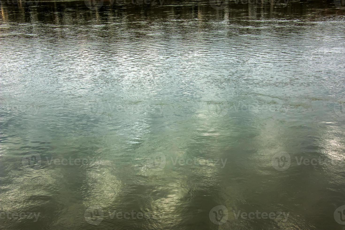 Background of the surface of the Danube river in a winter sunny day. Reflection of sun glare on the water surface with characteristic ripples. photo