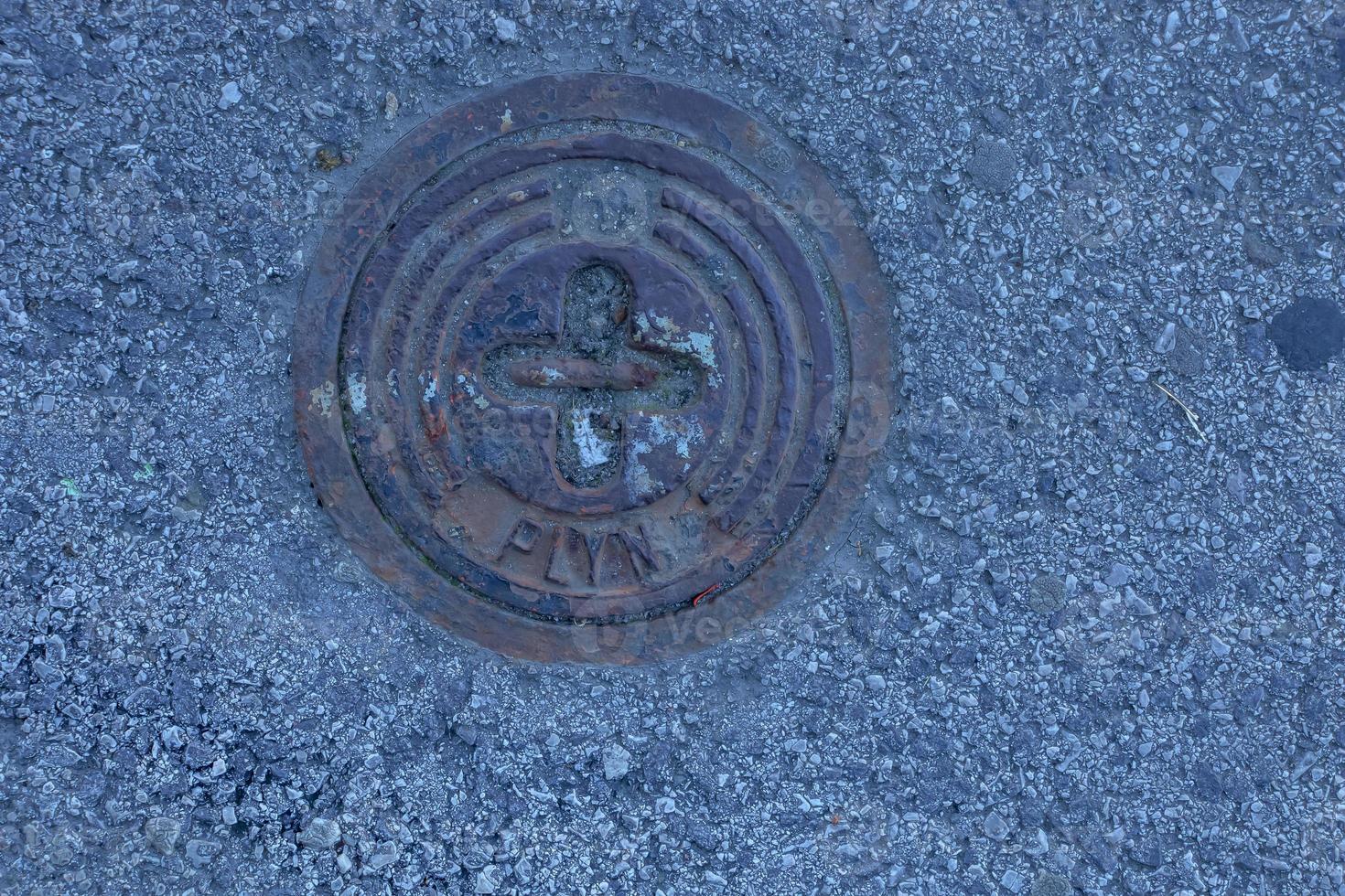 Manhole cover of the gas pipeline system. A massive metal hatch for access to city communications in the pavement. photo