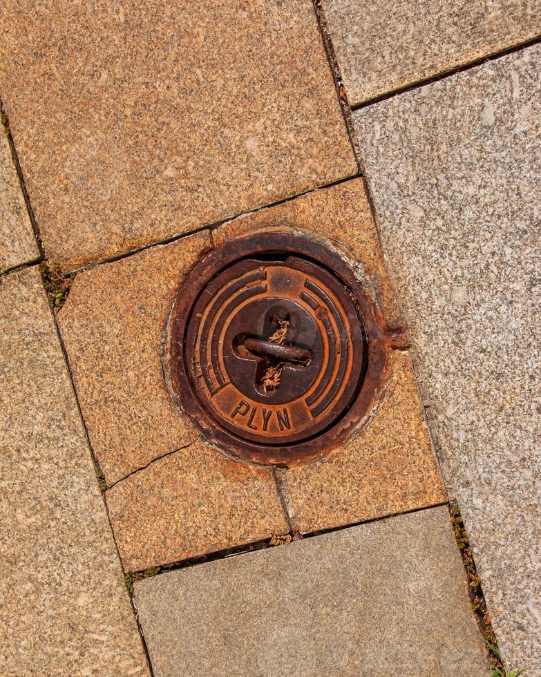 Manhole cover of the gas pipeline system. A massive metal hatch for access to city communications in the pavement. photo