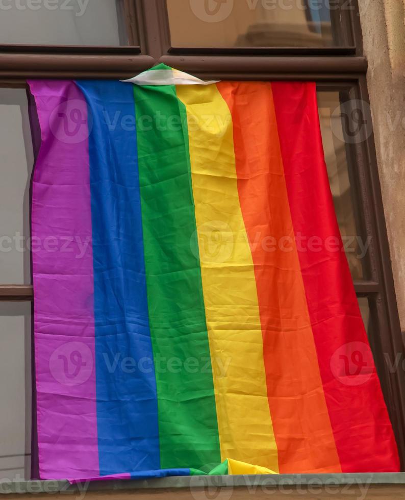 orgullo de la bandera del arco iris lgbt en la ciudad de bratislava. vista de la ventana de un edificio con una bandera del arco iris. foto