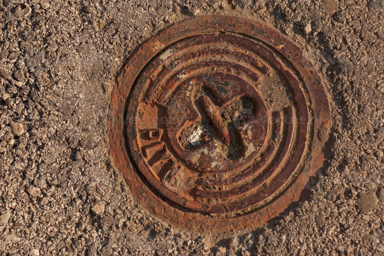 Manhole cover of the gas pipeline system. A massive metal hatch for access to city communications in the pavement. photo