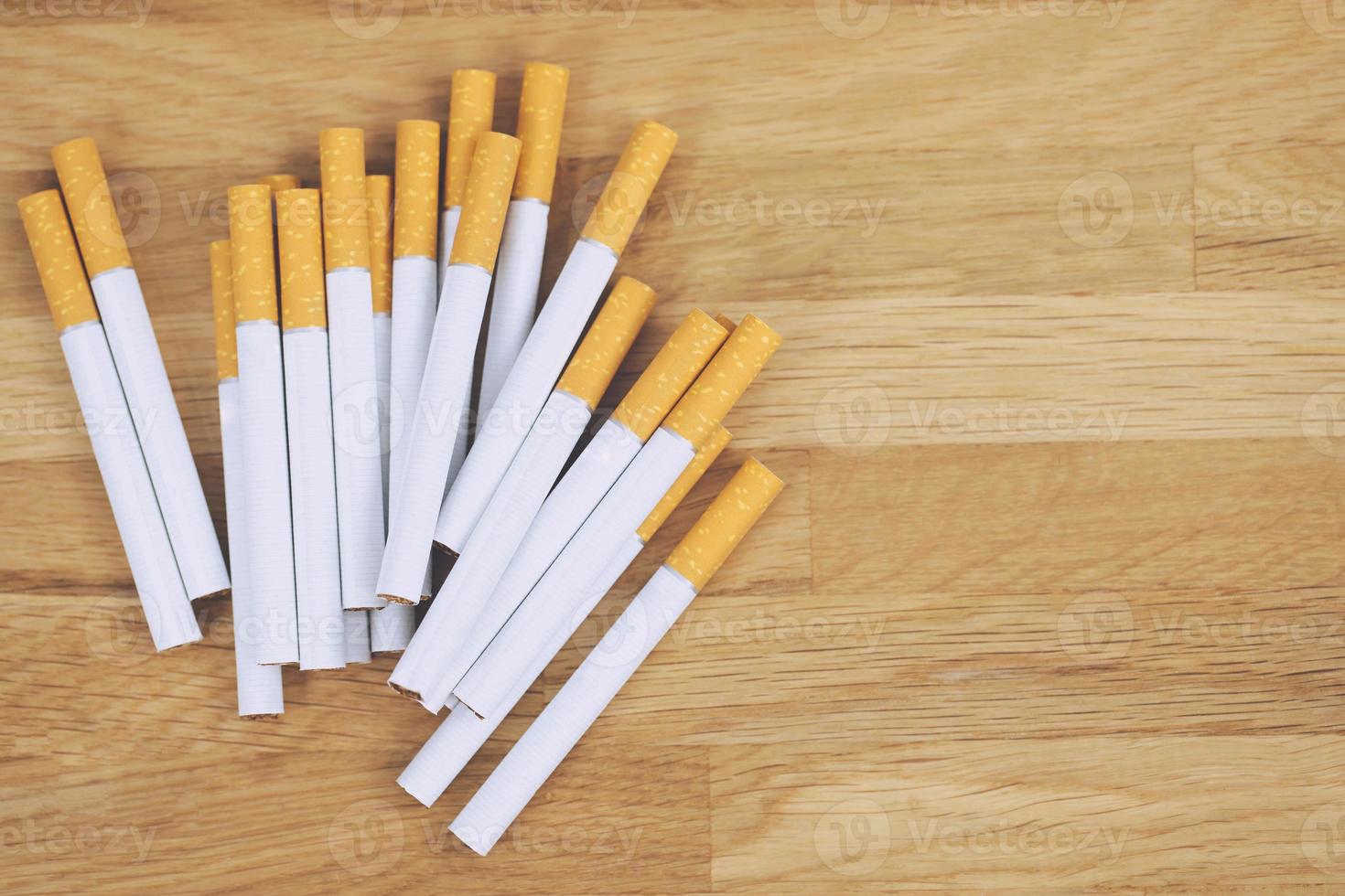 image of several commercially made cigarettes. pile cigarette on wooden dark background. or Non smoking campaign concept, tobacco. top view photo