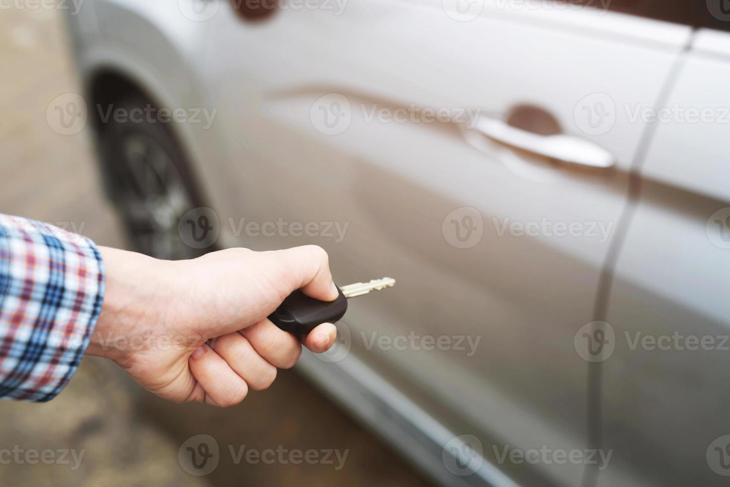 Cropped view of  Closeup of a man's hand inserting key into the door lock of a car photo