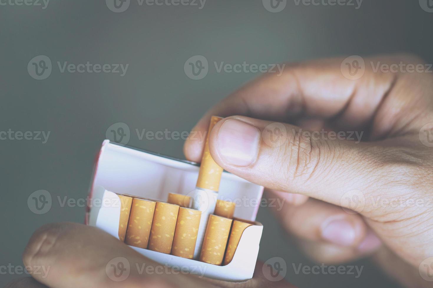 close up man hand holding peel it off cigarette pack prepare smoking a cigarette. Packing line up. photo filters Natural light.