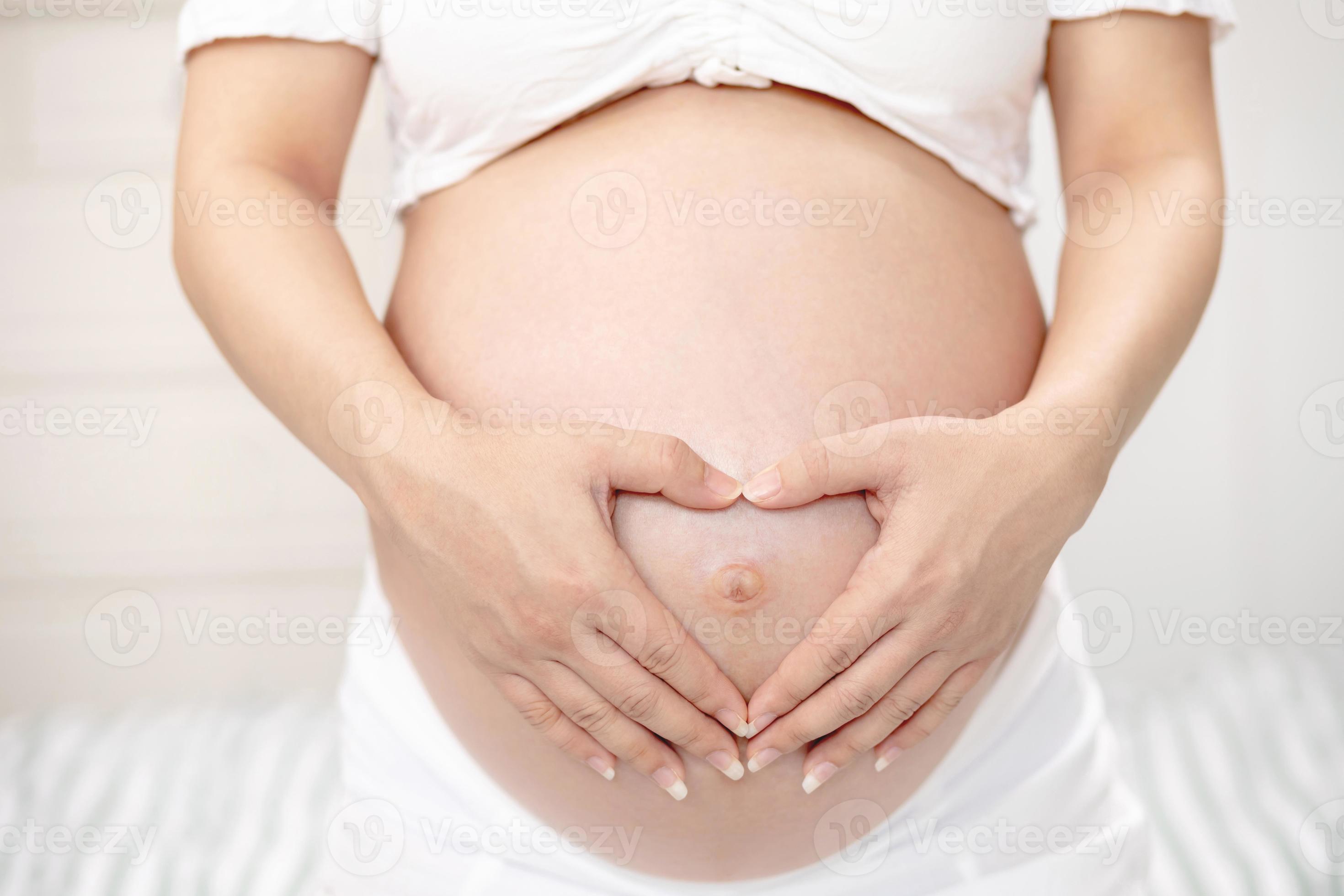 pregnant woman and her husband hand splice hugging the tummy Heart