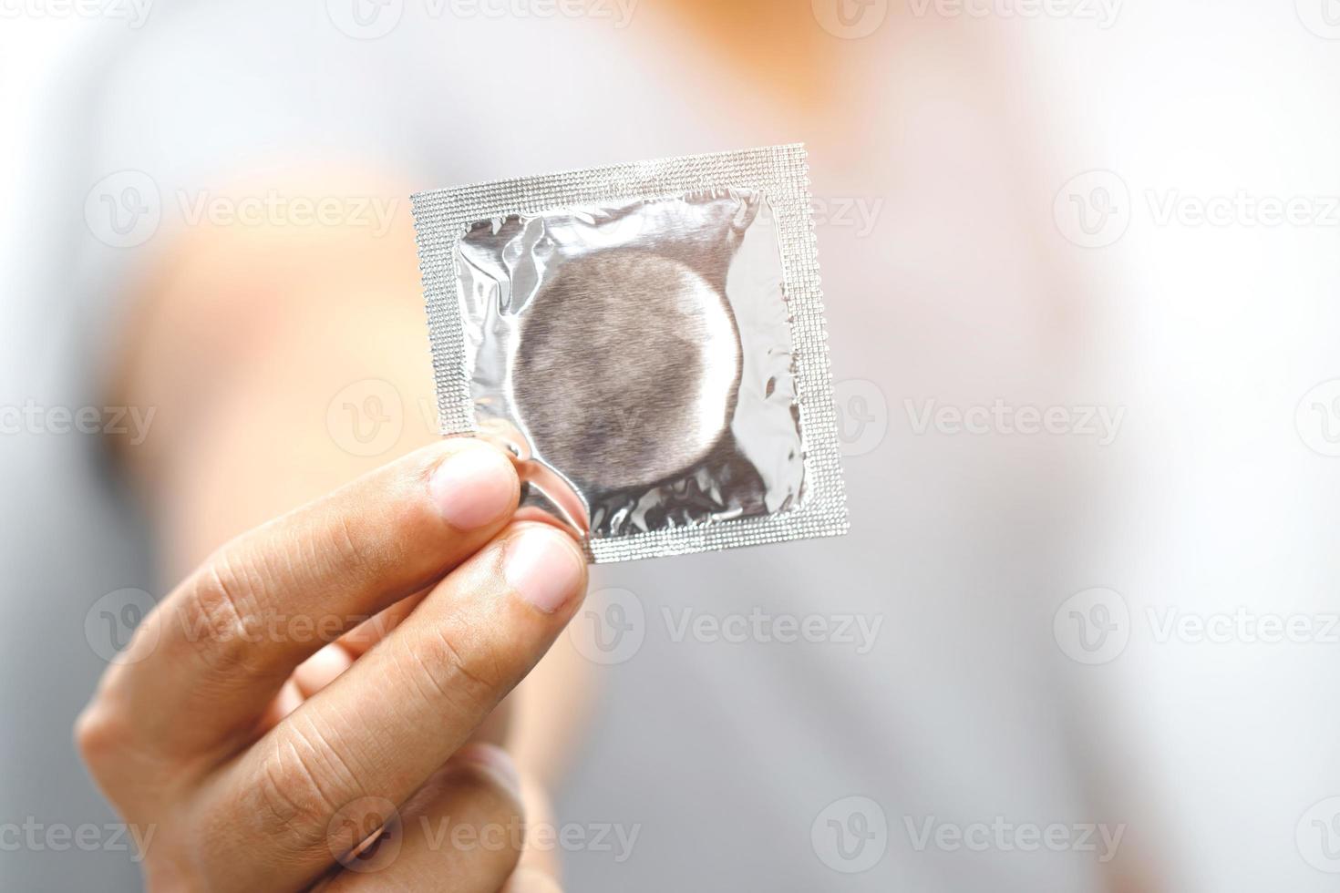 Condom ready to use in male hand, give condom safe sex concept on the bed Prevent infection photo