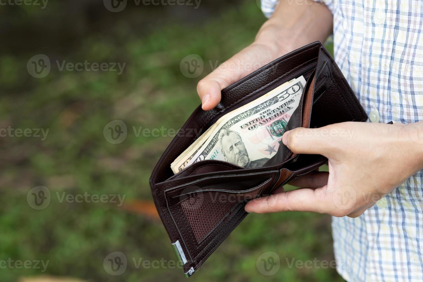 Businessman Person holding an wallet in the hands of an man take money out of pocket. photo