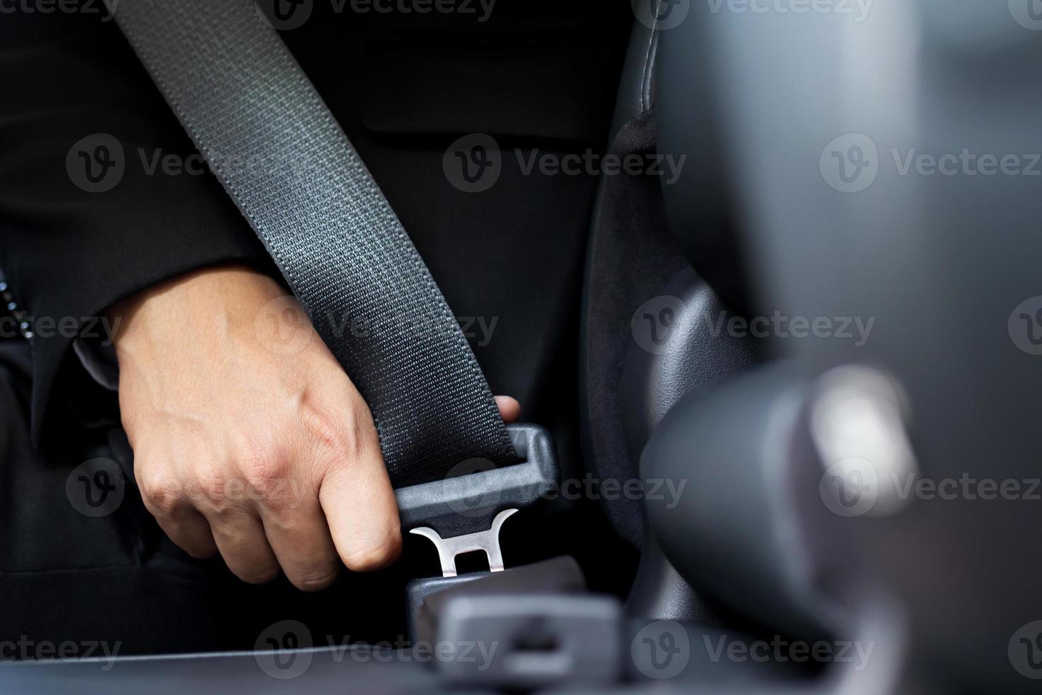 Close Up of people business man hand fastening seat safety belt in car photo