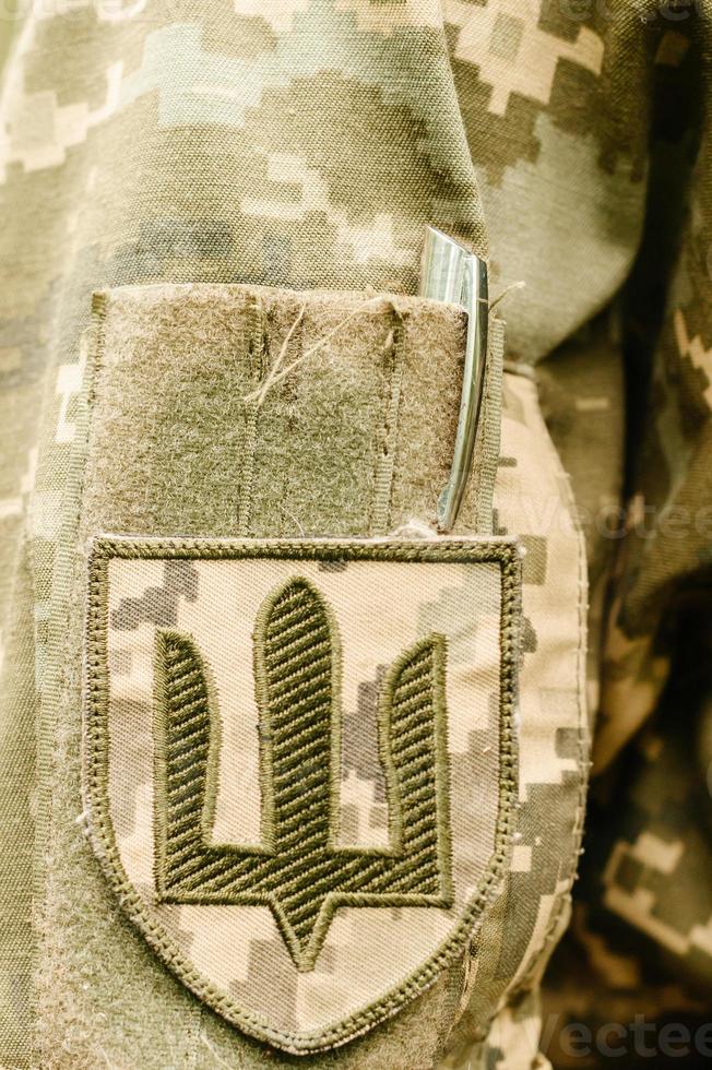 galones en el uniforme de píxel militar ucraniano. insignia de manga de las fuerzas terrestres de ucrania. foto