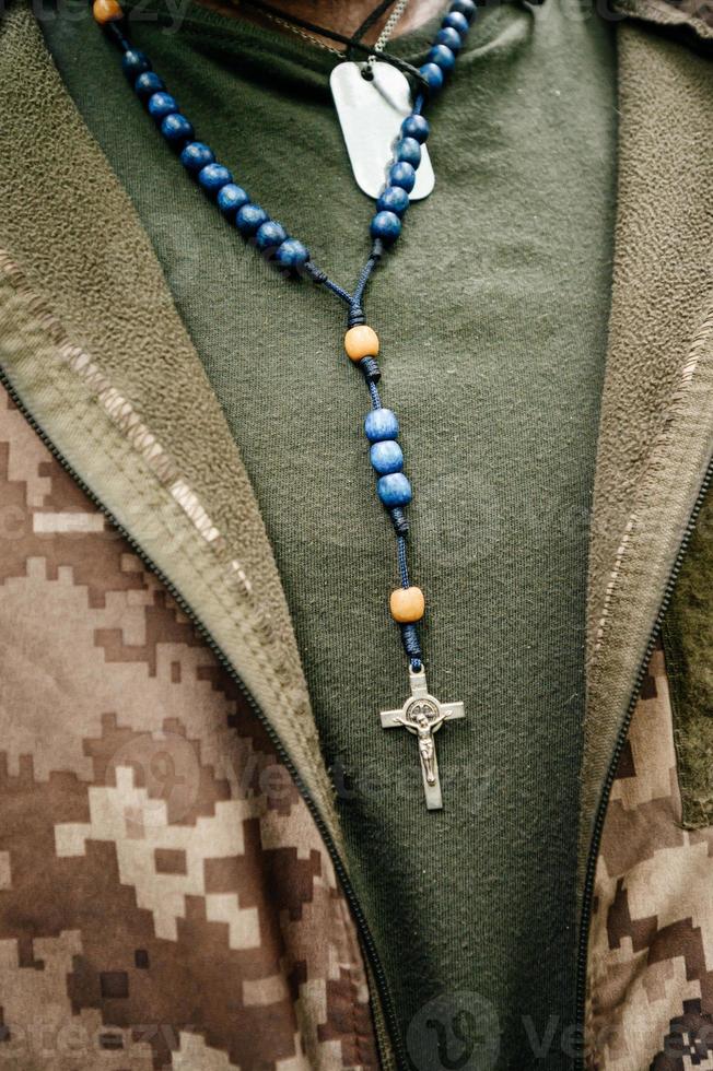 The Ukrainian military wears a rosary and military dog tags on his chest, photo
