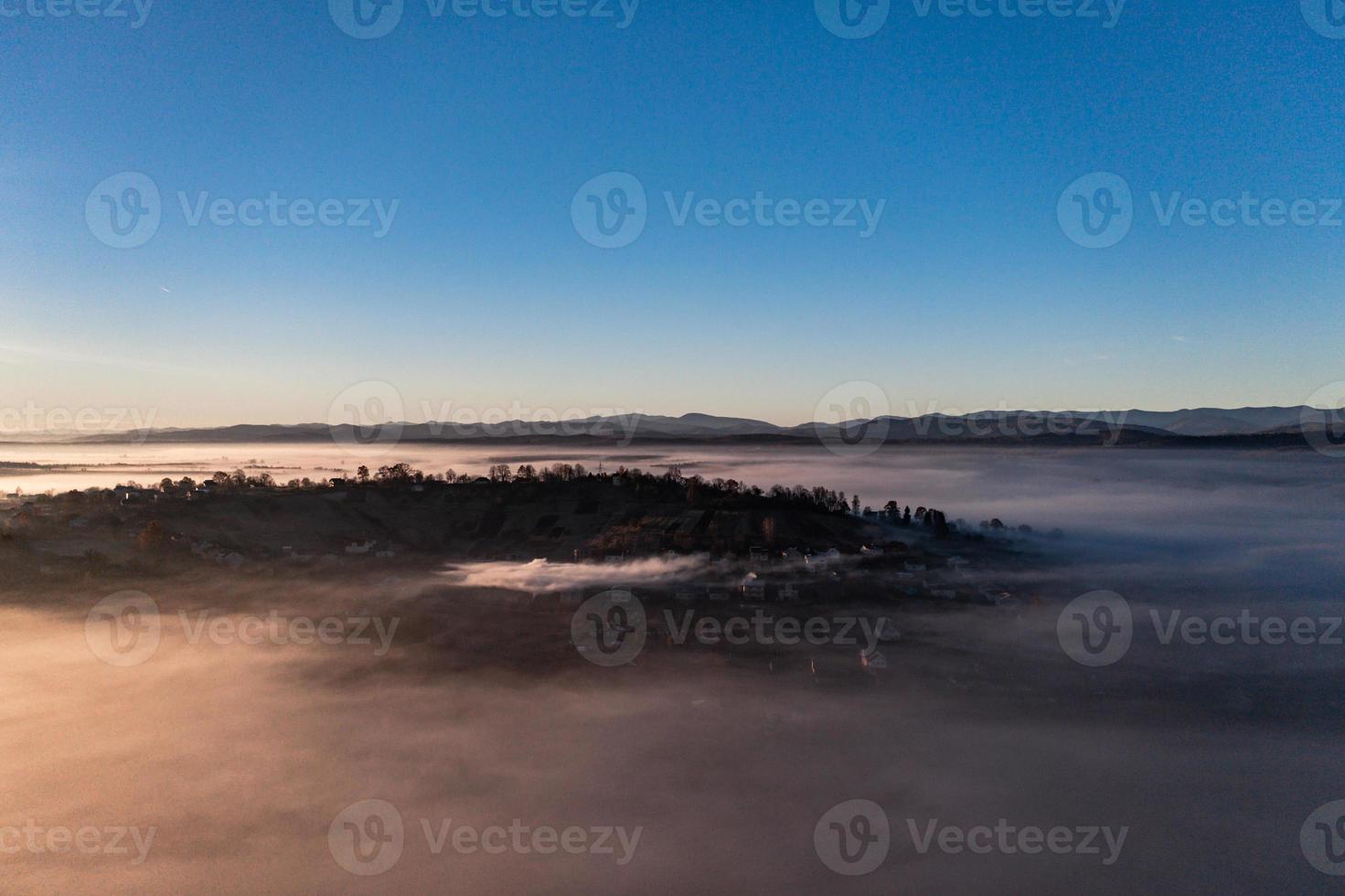 Photo from a drone over the village when the fog fell with thick clouds, a beautiful morning over the village.