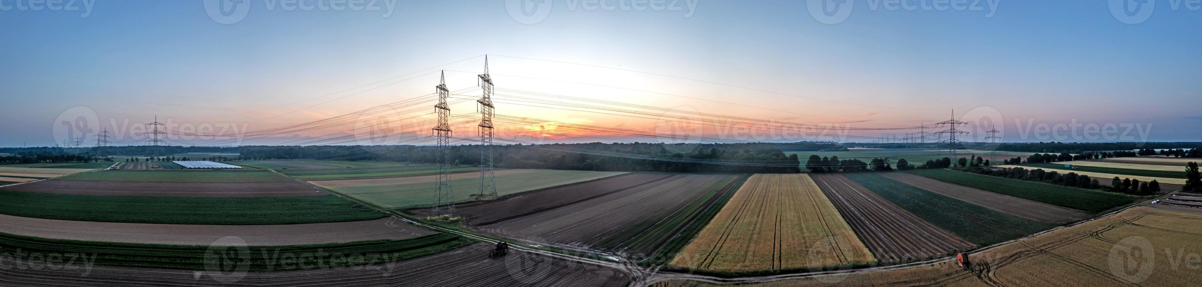 Panoramic image of power line over land during sunset in afterglow photo