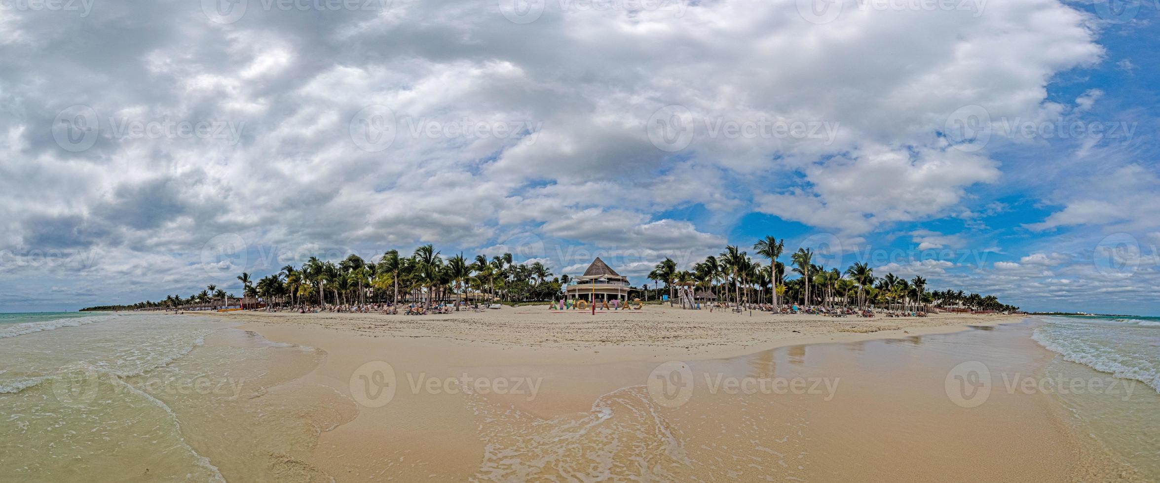Panorama over a tropical beach taken from the water during the day with sunshine photo