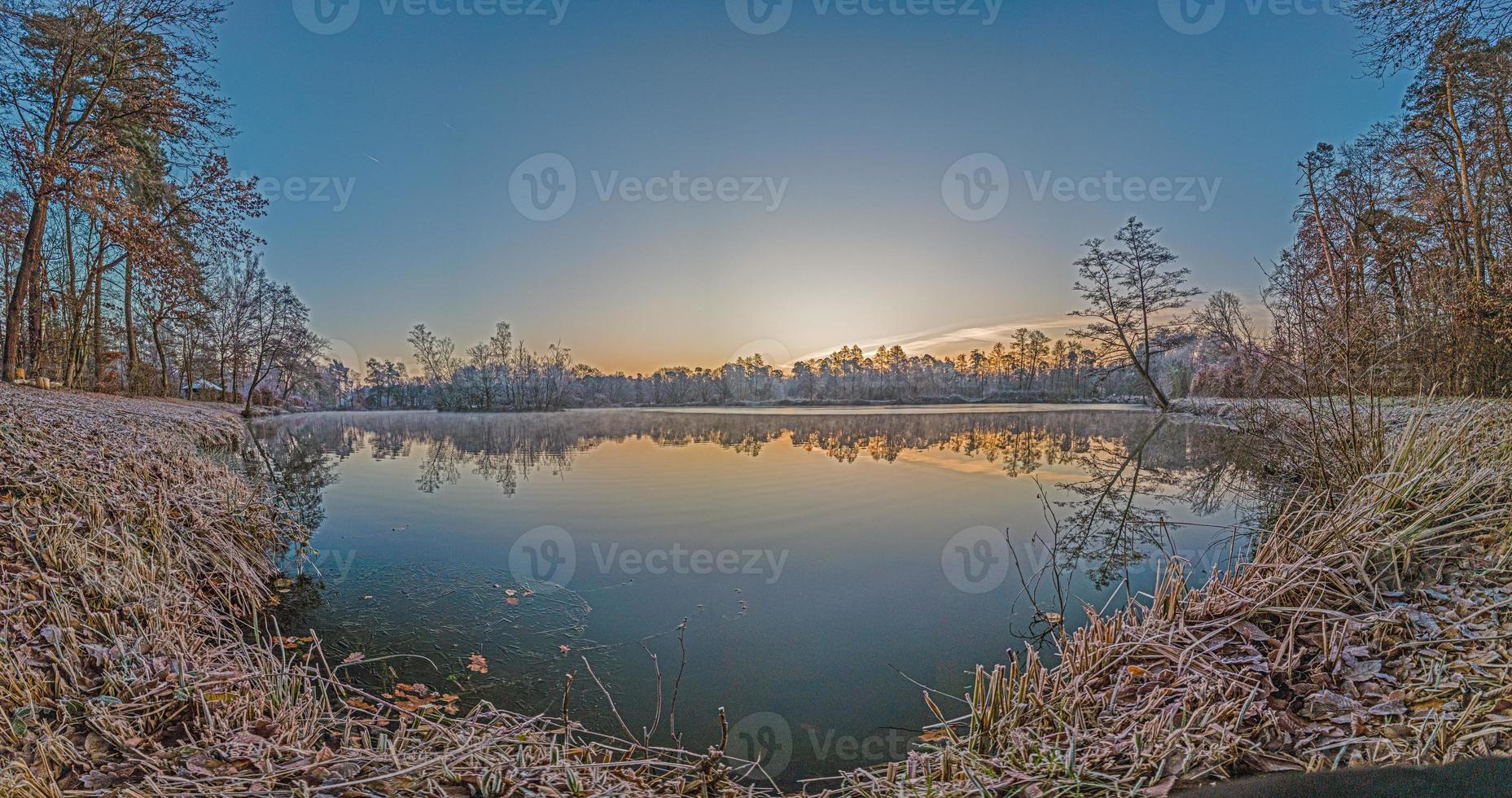 Panoramic image of frozen lake at frosty temperature during sunrise photo