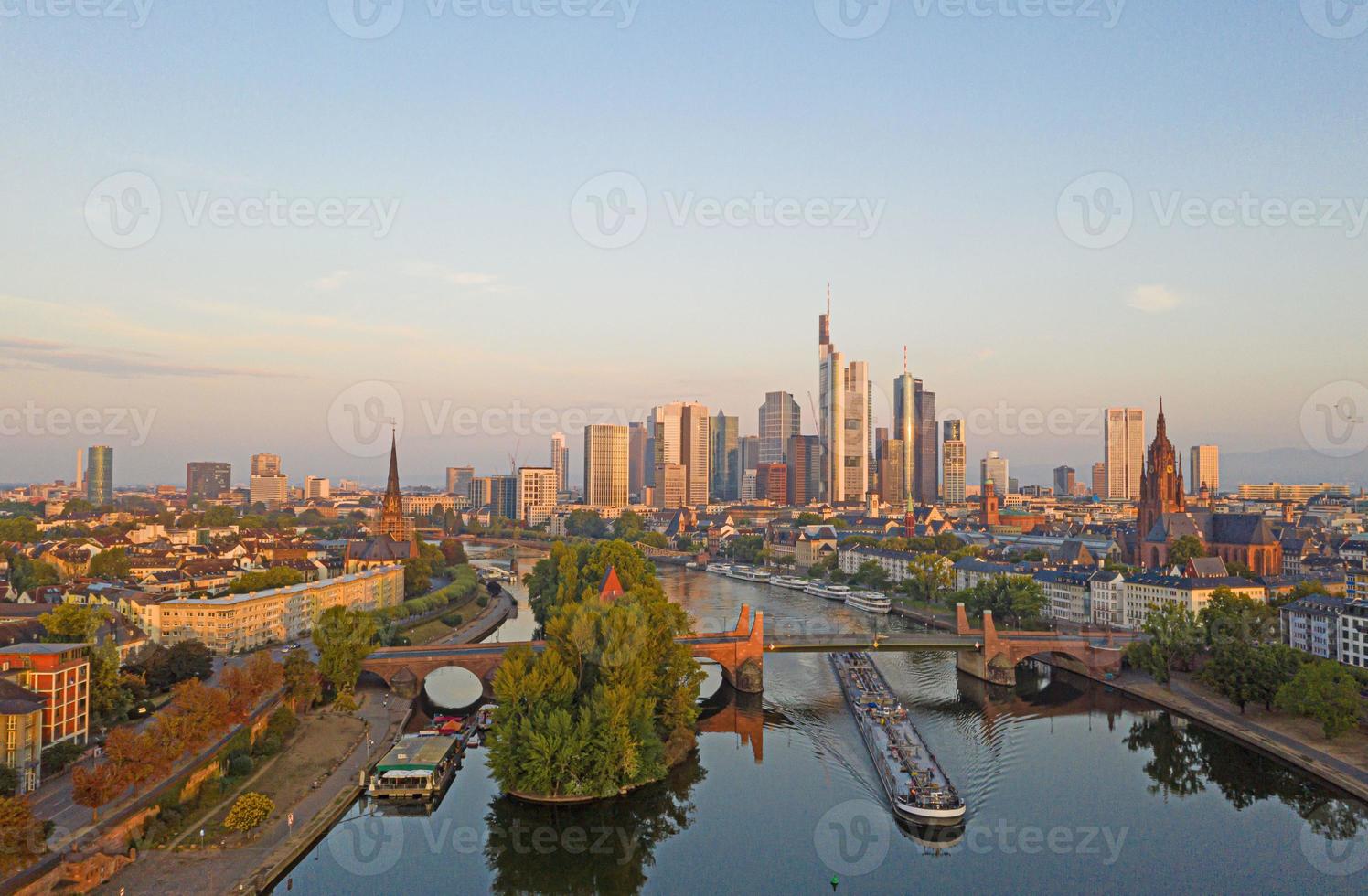 imagen aérea del horizonte de frankfurt y el río principal durante el amanecer con reflejos en el agua y las fachadas de vidrio de los rascacielos foto