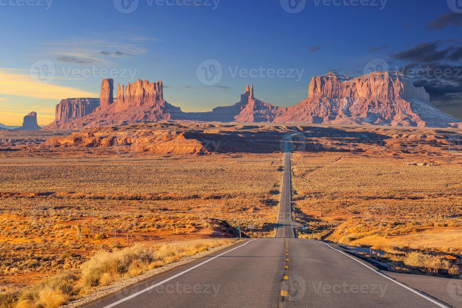 Endless street towards impressive rock formations of the Monument Valley National Park at evening in winter photo