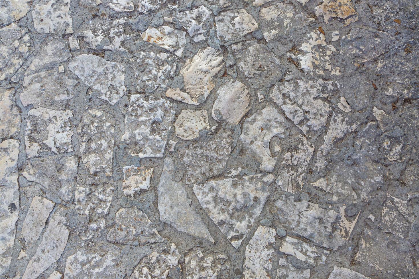 Closeup of an old natural stone wall with typical texture photo