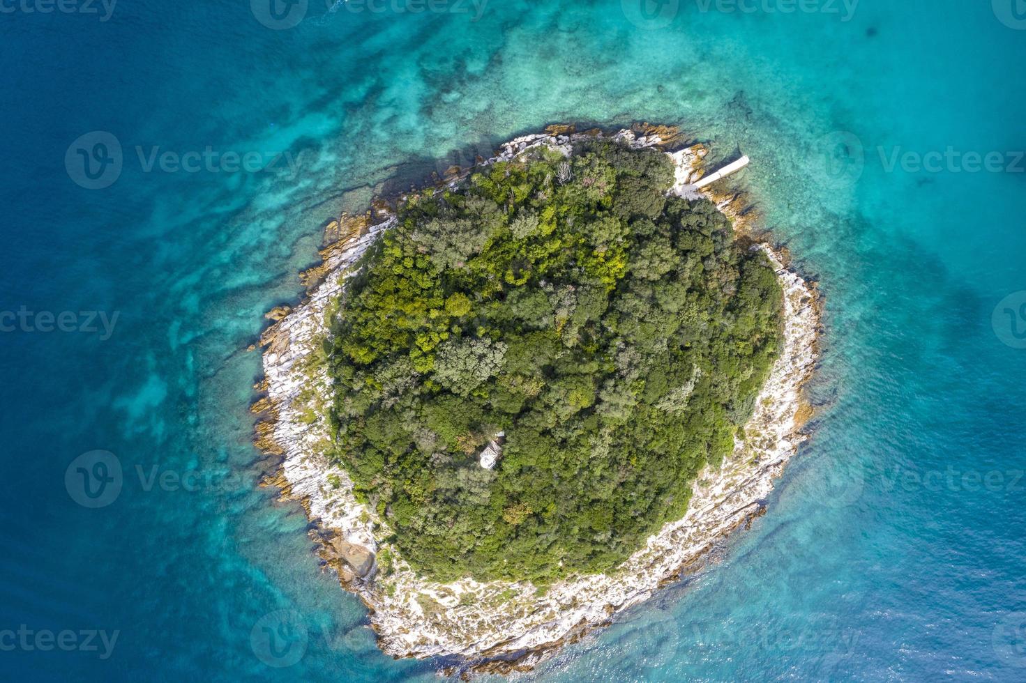 Vertical top view on a small island in the mediterrean sea close to the shore photo