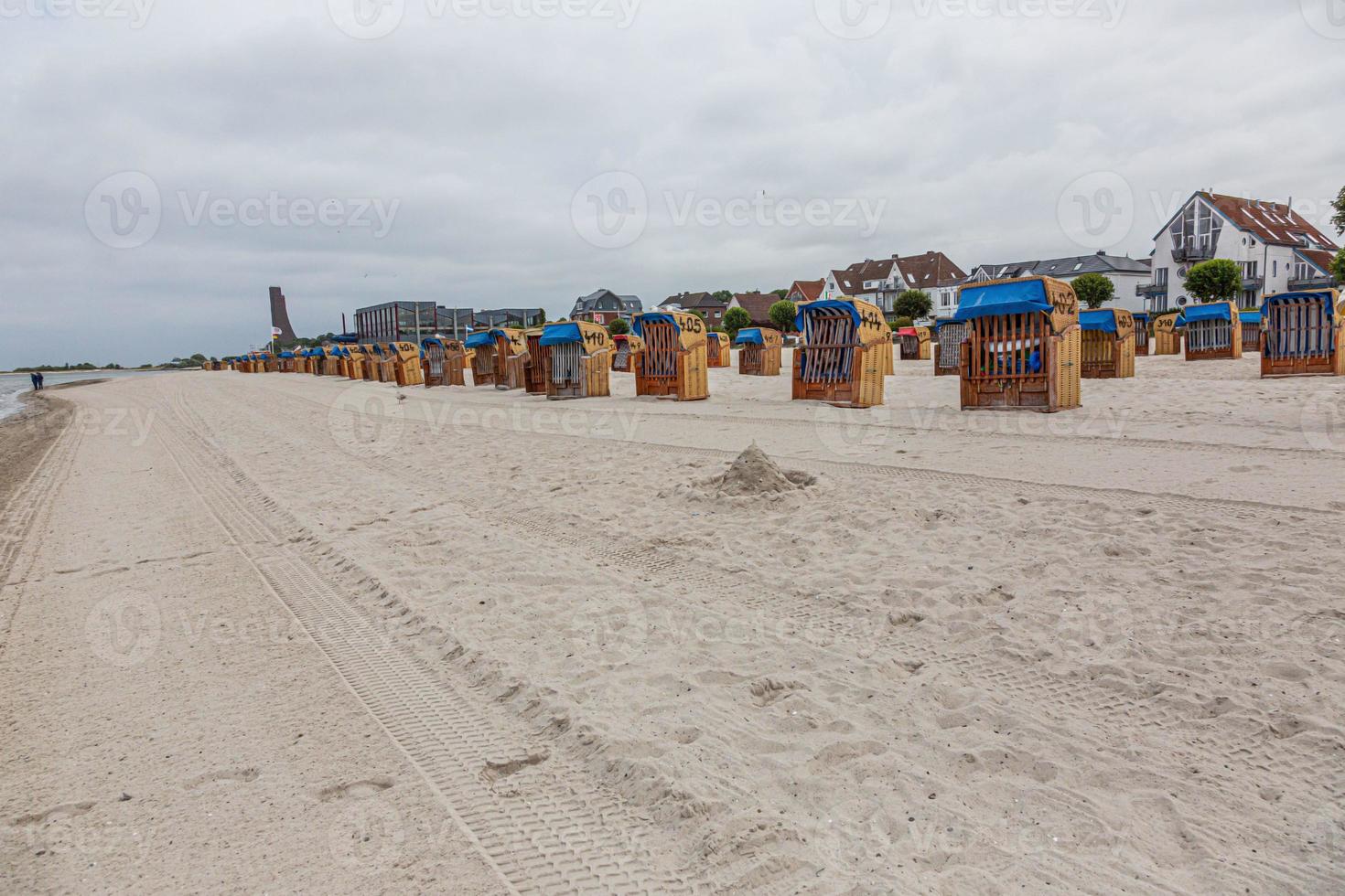 Roofed wicker beach chairs at beach of German village Laboe in summer photo