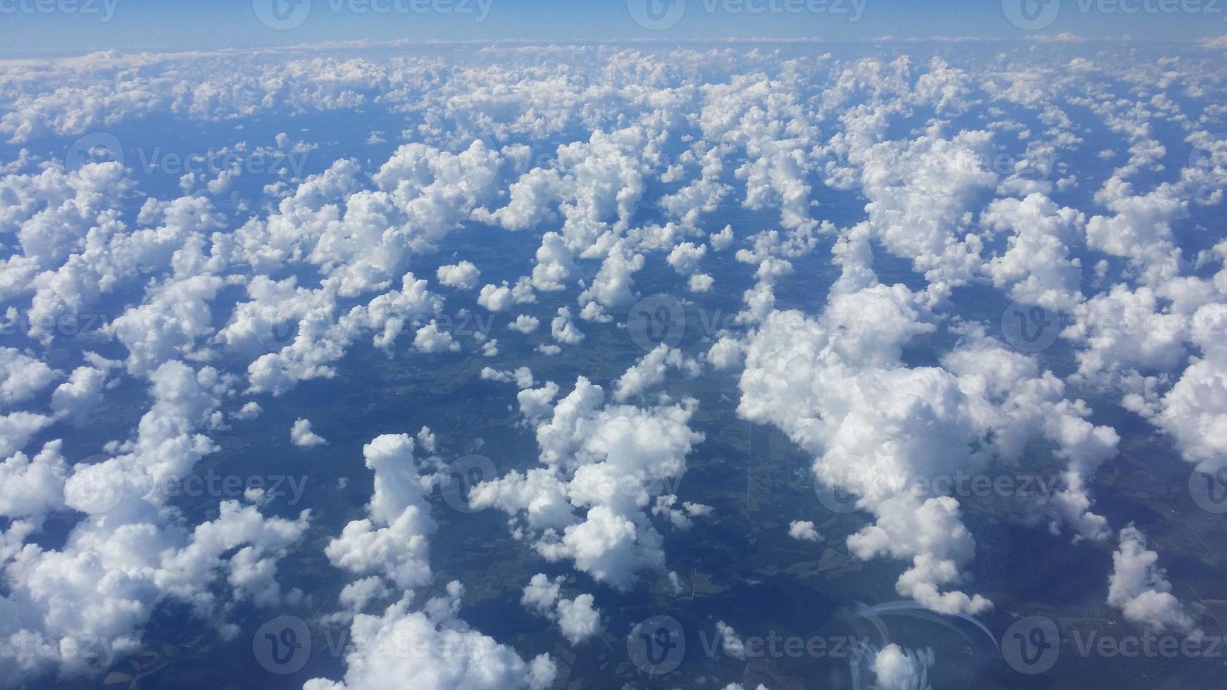 Image of loosened clouds from above taken from an airplane photo