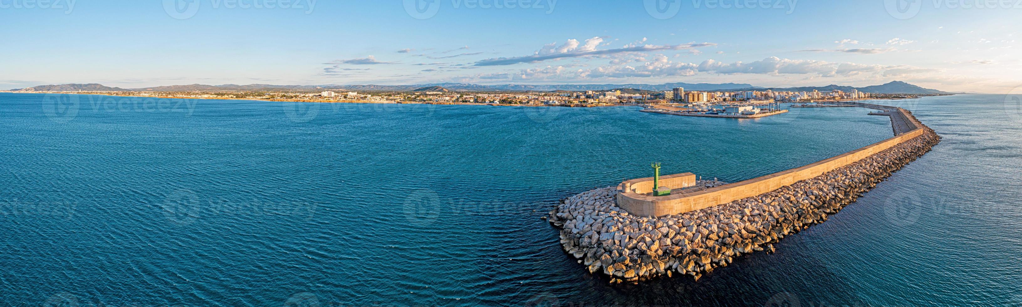 Drone panorama of the Spanish town of Vinaros with the large breakwater at the entrance to the port during sunrise photo