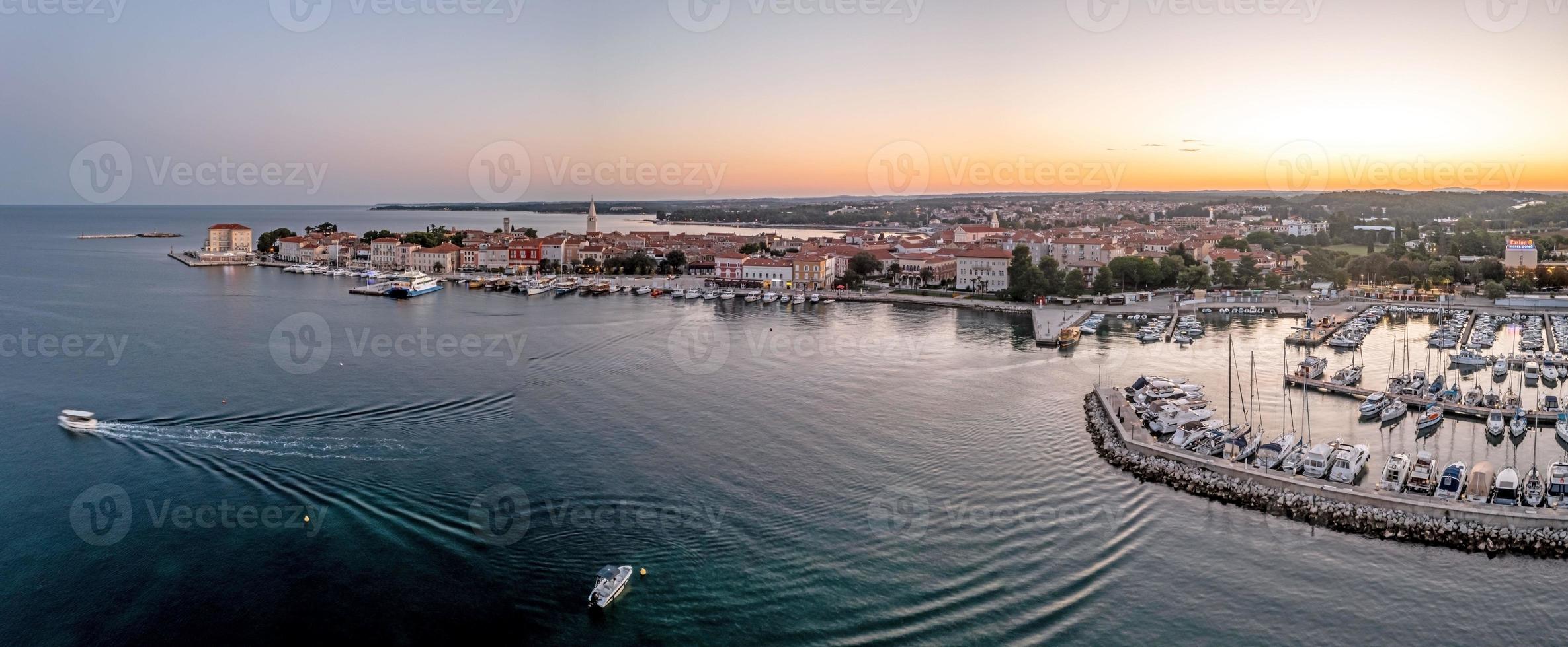 panorama de drones de la ciudad costera croata de porec con puerto y paseo marítimo durante el amanecer foto
