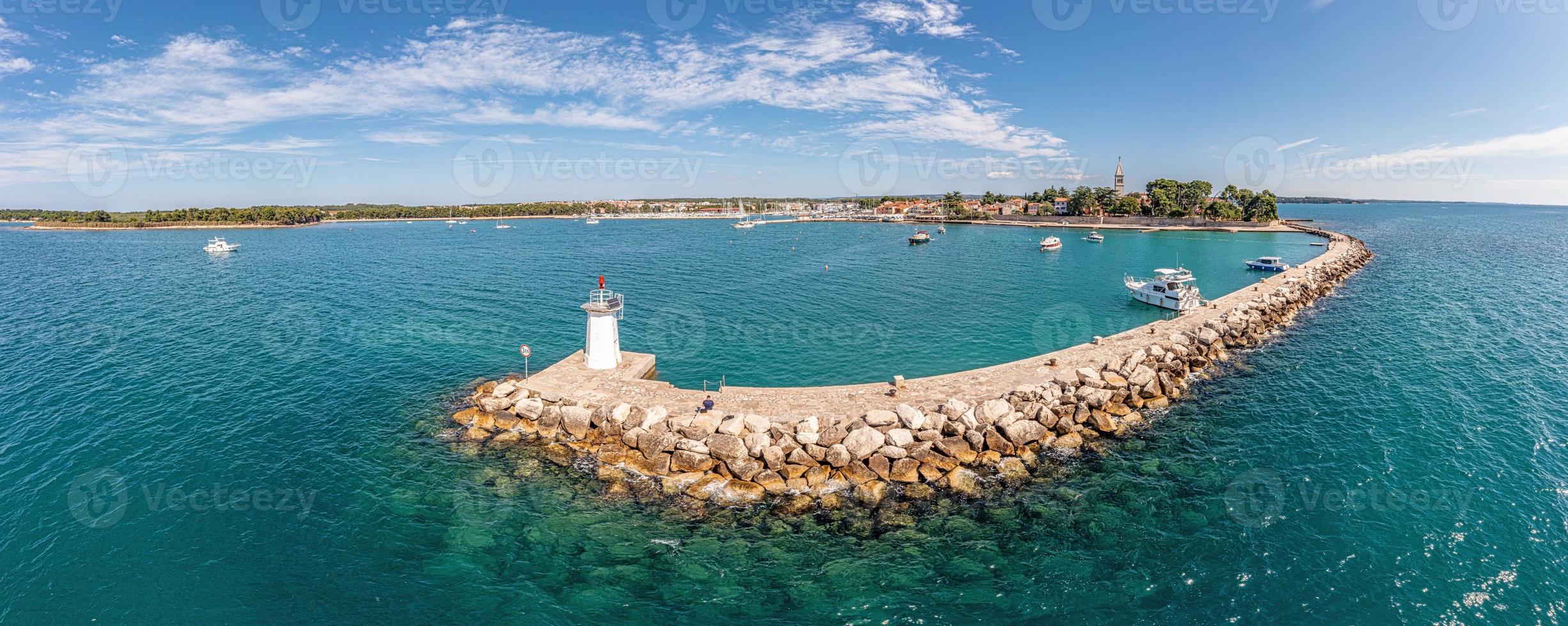 Drone panorama over the Croatian coastal town Novigrad with harbor and promenade taken from the sea side during the day photo