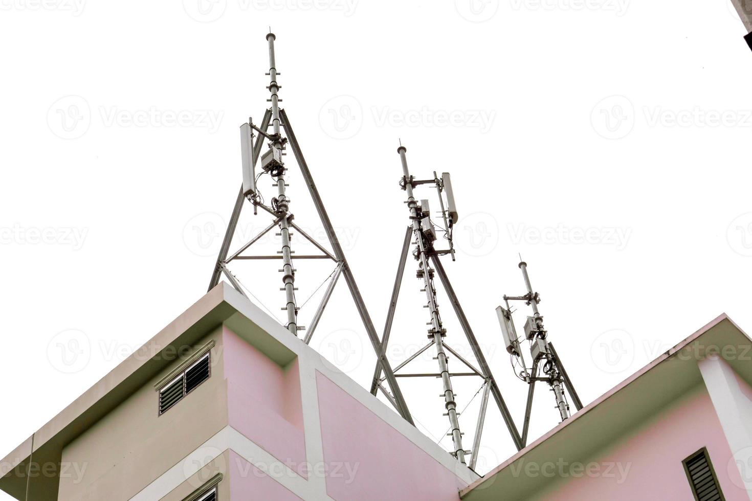 torre de comunicación con antenas en la parte superior del edificio aislado sobre fondo blanco. foto