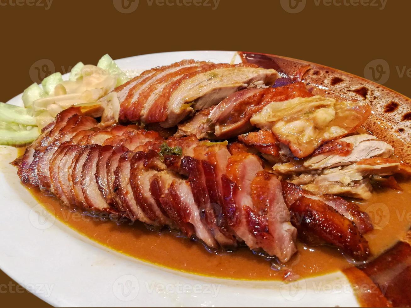 Roasted duck and grilled pork isolate on brown background. photo