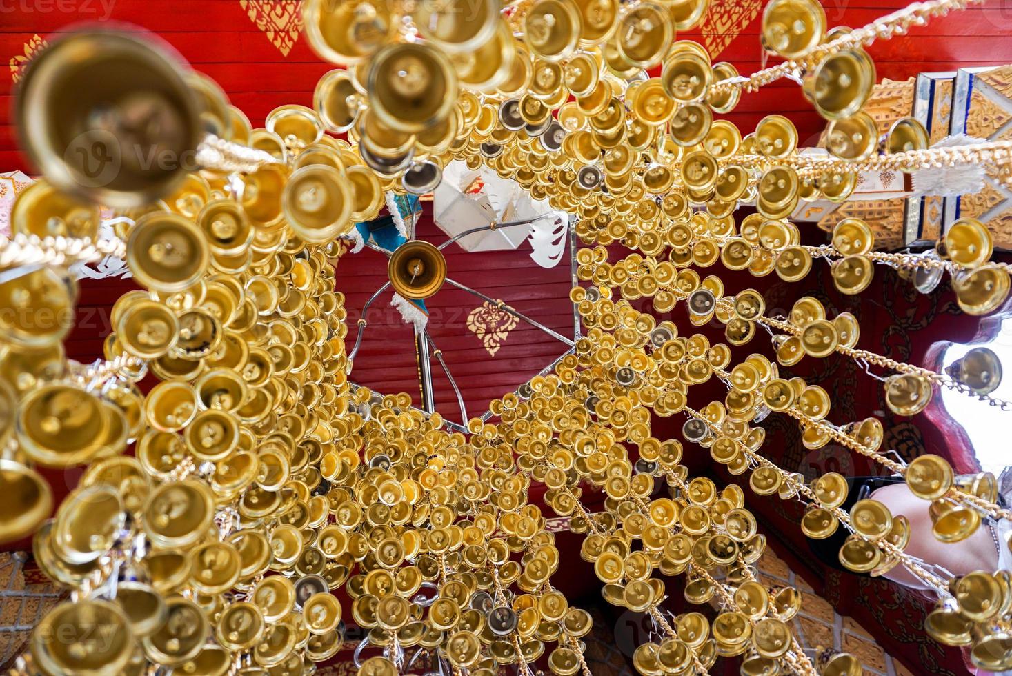 Look up view of of many small golden bells was hung in a group in Thai temple photo