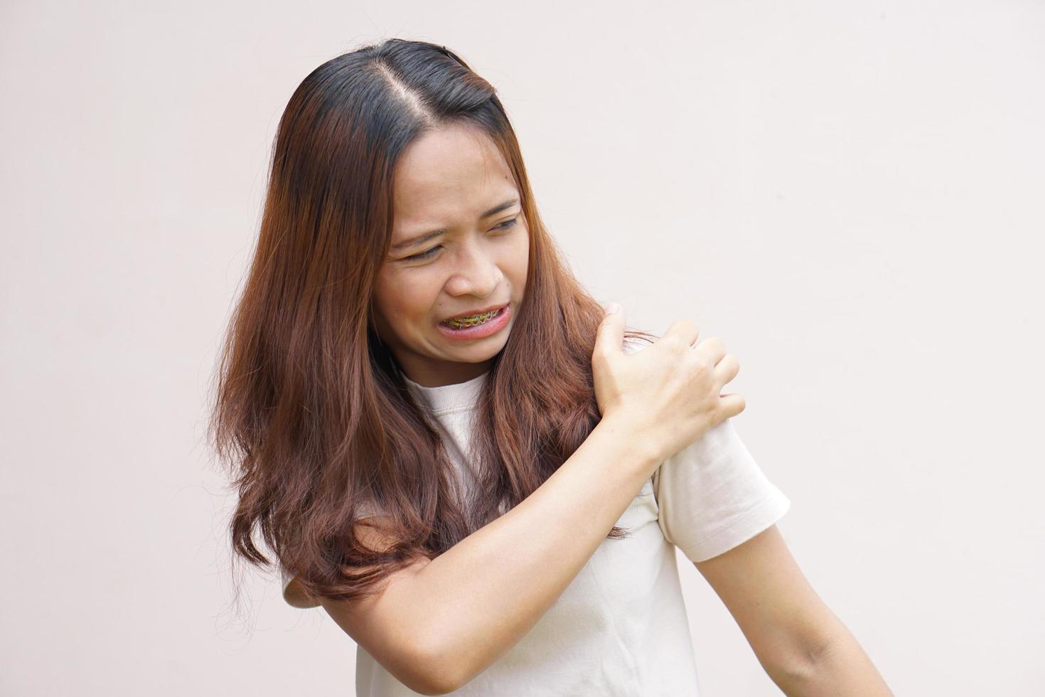 mujer asiática con dolor de hombro foto