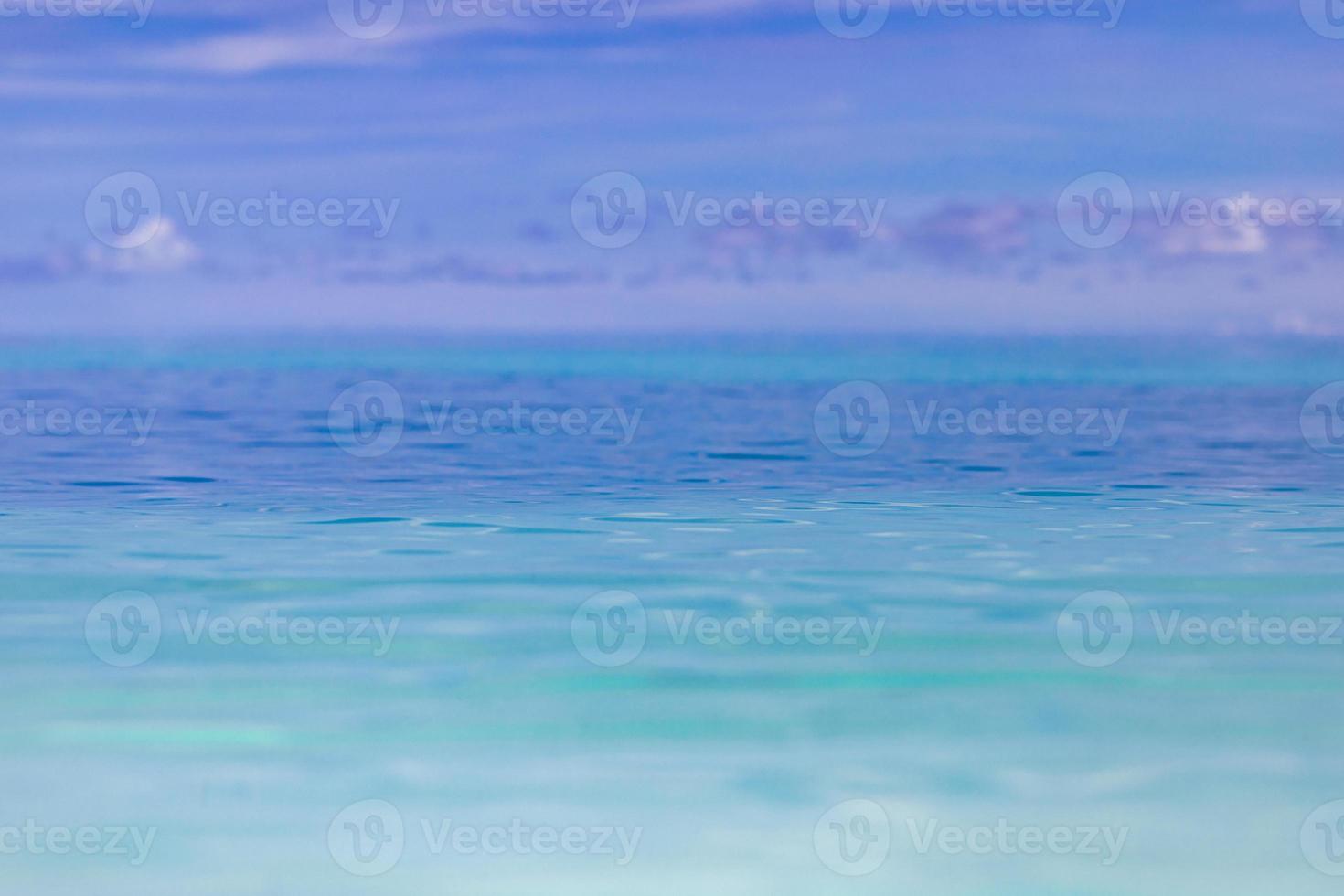 Clear sky and calm sea or ocean water surface on blurred background with shallow depth of field. Artistic sea, ocean closeup photo