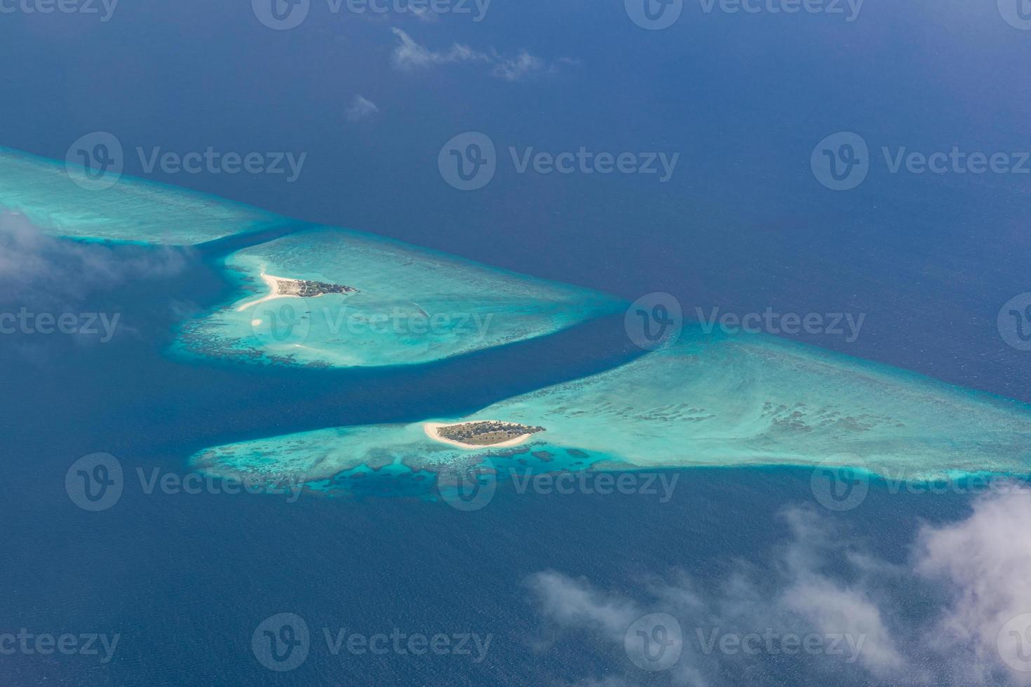 Aerial view of Maldives resort, luxury travel destination. Birds eye view of deep blue sea, coral reed, tropical island. Amazing nature view, drone aerial landscape photo