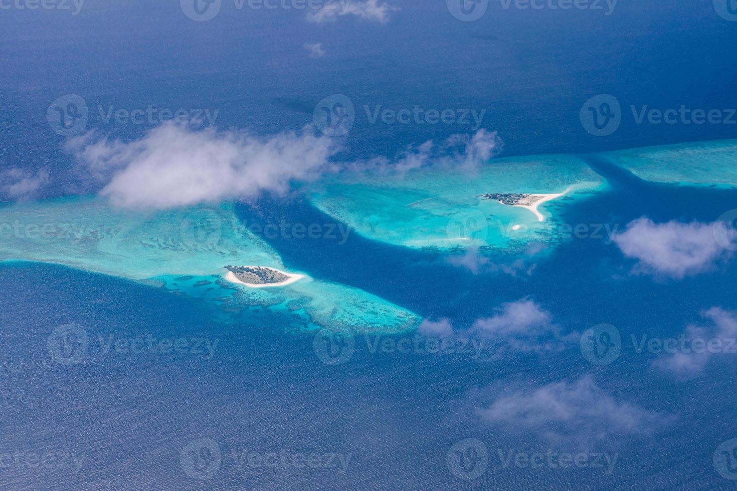 Aerial view of Maldives resort, luxury travel destination. Birds eye view of deep blue sea, coral reed, tropical island. Amazing nature view, drone aerial landscape photo