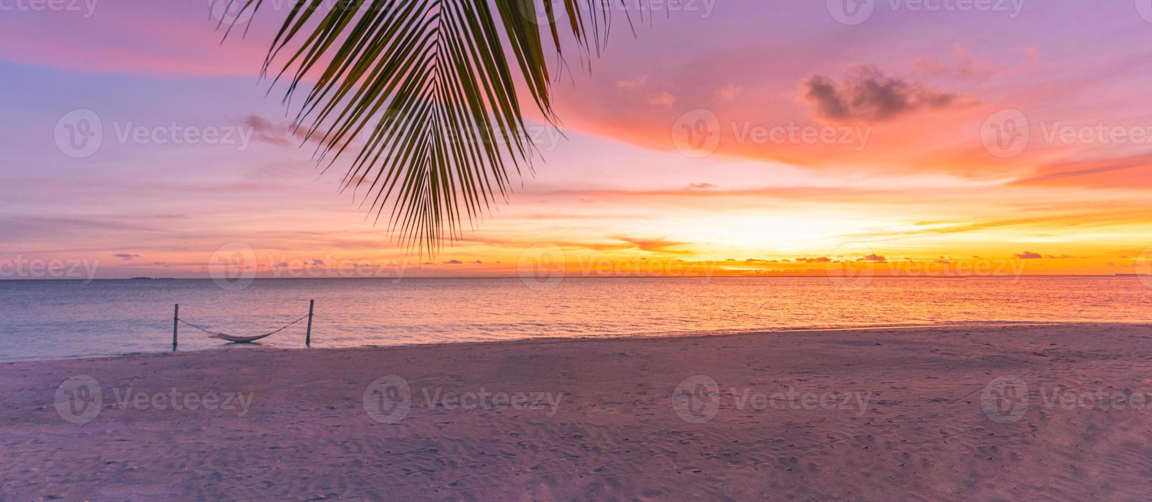 Blurred beach sunset. Palm leaf with colorful sky in sunset. Summer landscape, amazing peaceful mood. Nature landscape at tropical beach. Sea sand sunset sky with horizon, wonderful landscape scenery photo