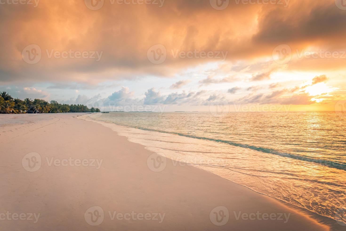 Closeup of sea beach and colorful sunset sky. Panoramic beach landscape. Empty tropical beach and seascape. Orange and golden sunset sky, soft sand, calmness, tranquil relaxing sunlight, summer mood photo