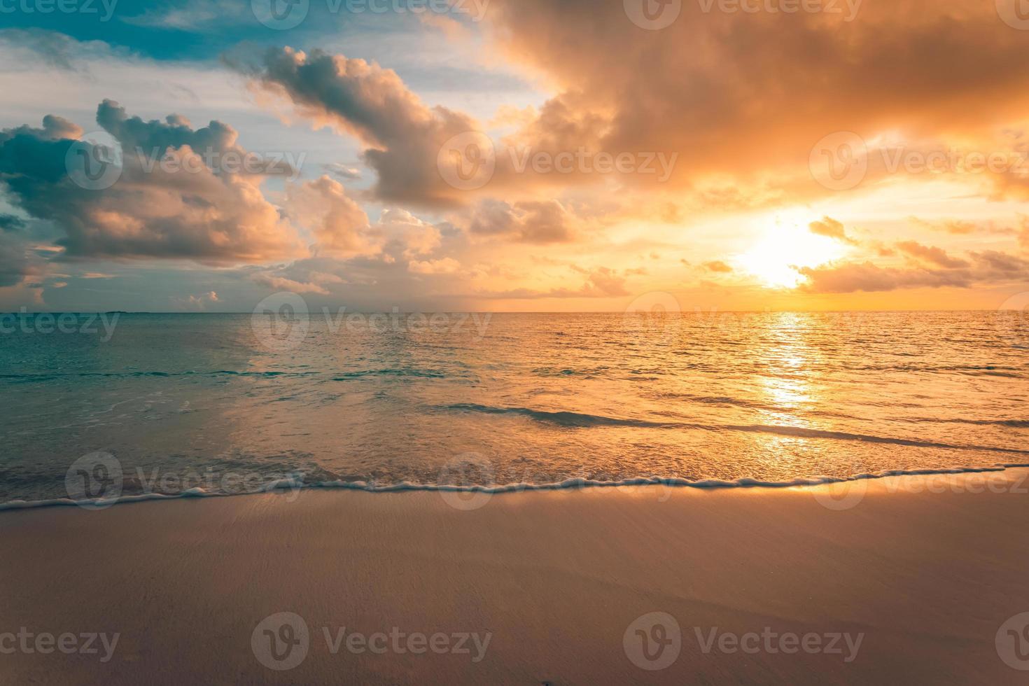 Closeup of sea beach and colorful sunset sky. Panoramic beach landscape. Empty tropical beach and seascape. Orange and golden sunset sky, soft sand, calmness, tranquil relaxing sunlight, summer mood photo