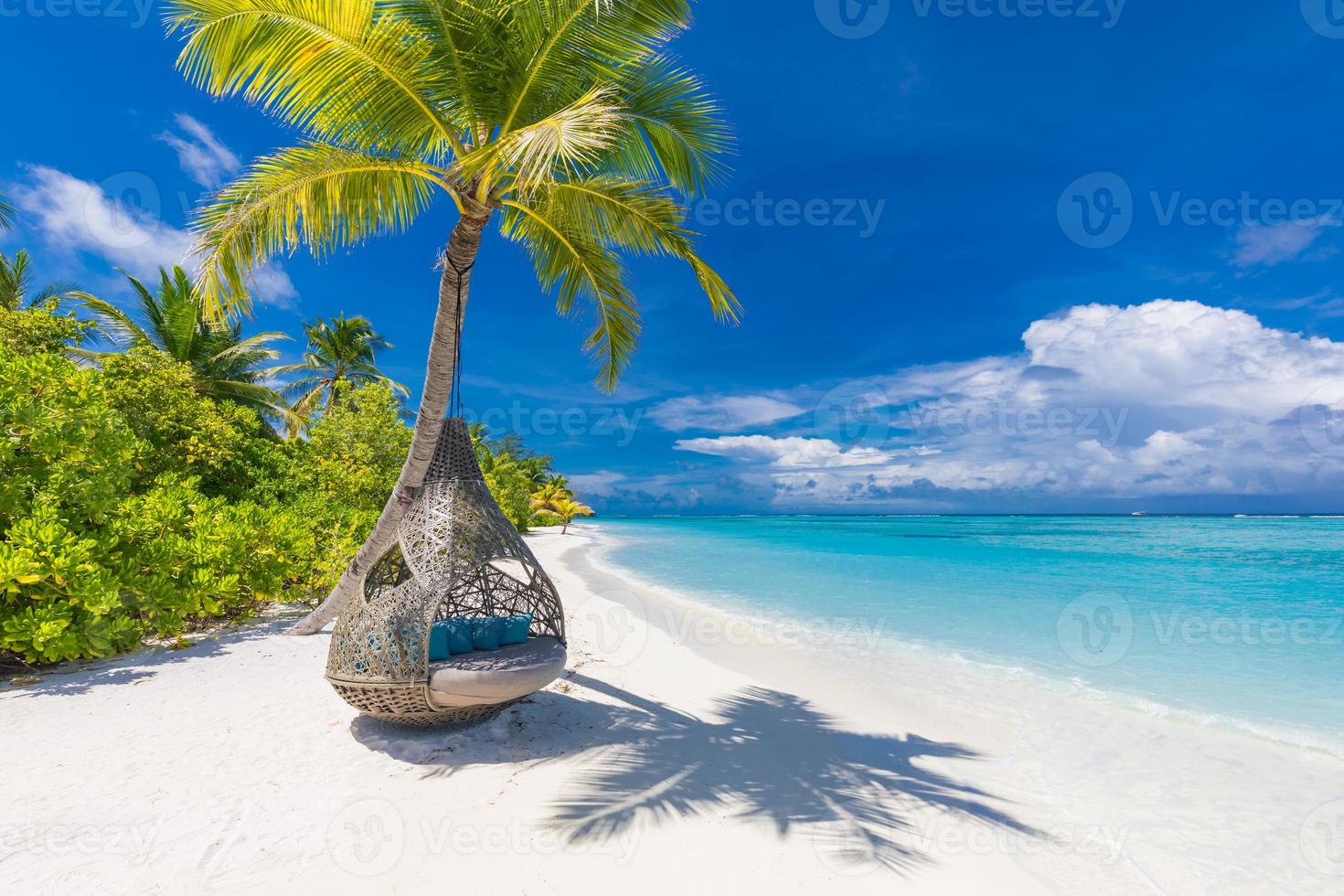 Tropical beach background as summer landscape with beach swing or hammock and white sand and calm sea for beach banner. Perfect beach scene vacation and summer holiday concept. Boost up color process photo