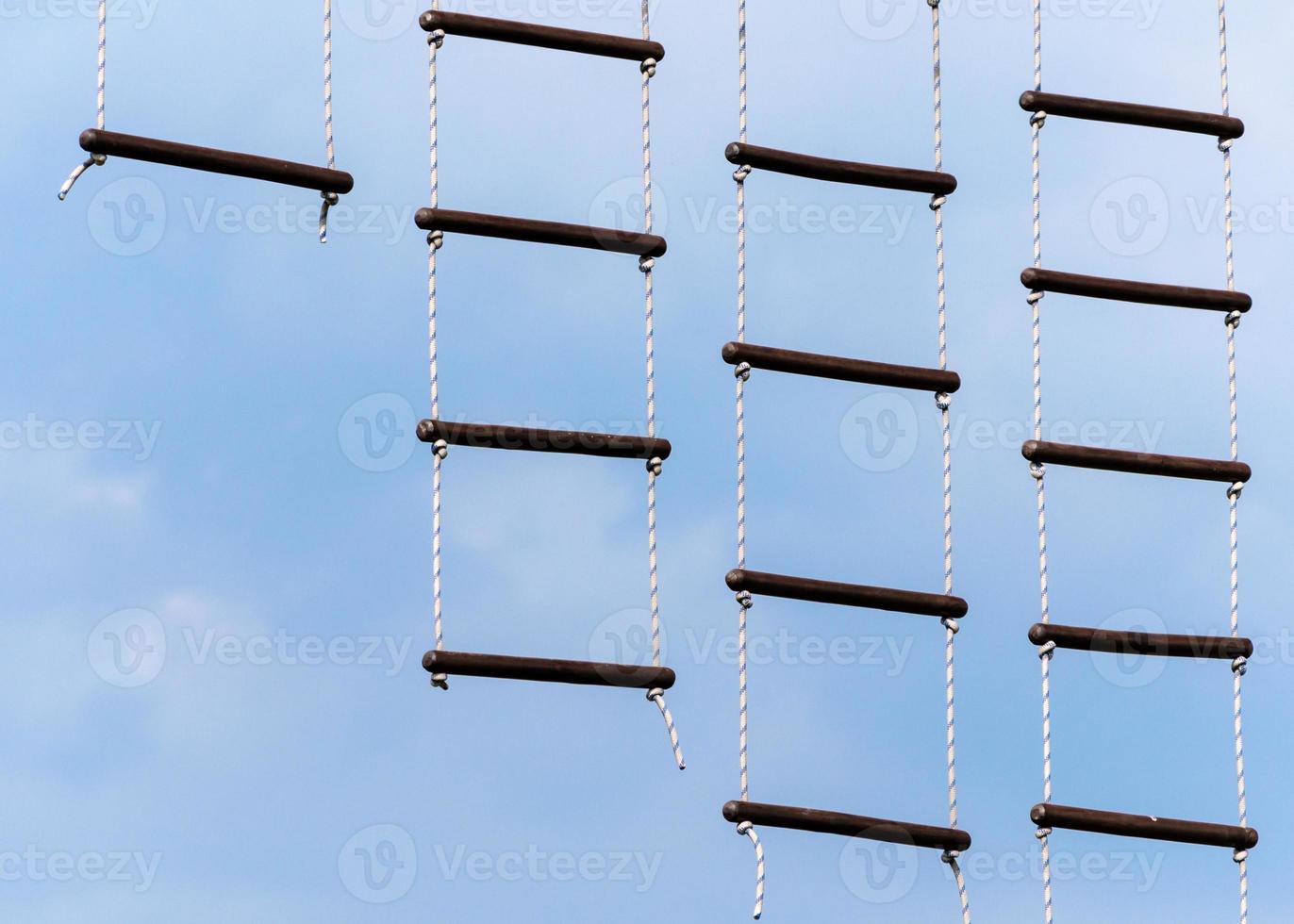 rope ladder against a blue sky and clouds photo