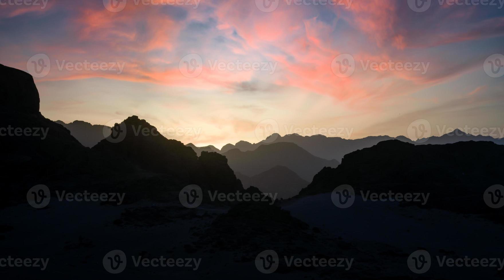 peaks of mountains in the desert against sunset photo