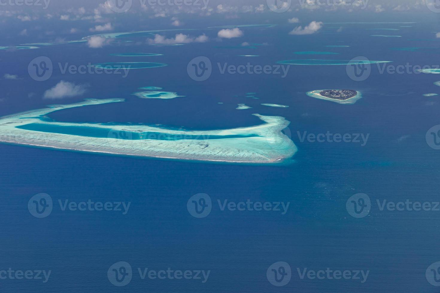 vista aérea del complejo de maldivas, destino de viaje de lujo. vista de pájaro del mar azul profundo, caña de coral, isla tropical. increíble vista de la naturaleza, paisaje aéreo de drones foto