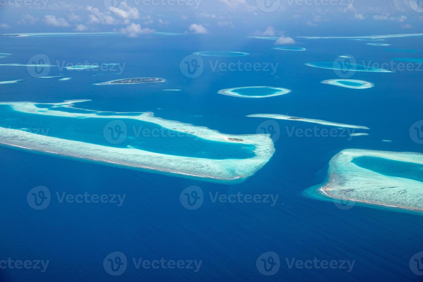 Aerial view of Maldives resort, luxury travel destination. Birds eye view of deep blue sea, coral reed, tropical island. Amazing nature view, drone aerial landscape photo