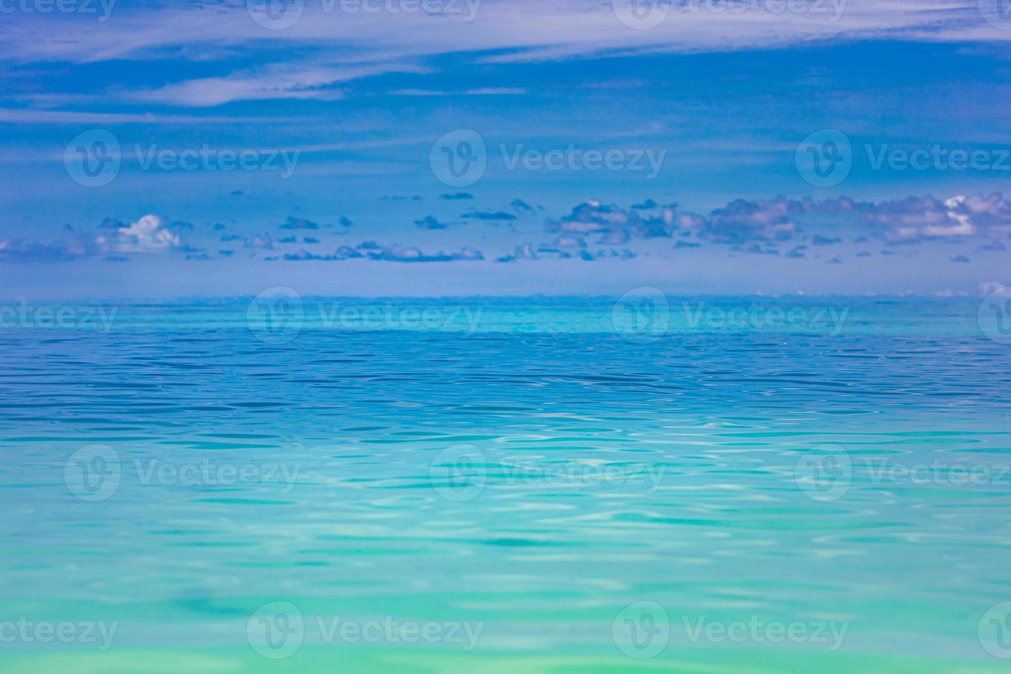 Clear sky and calm sea or ocean water surface on blurred background with shallow depth of field. Artistic sea, ocean closeup photo