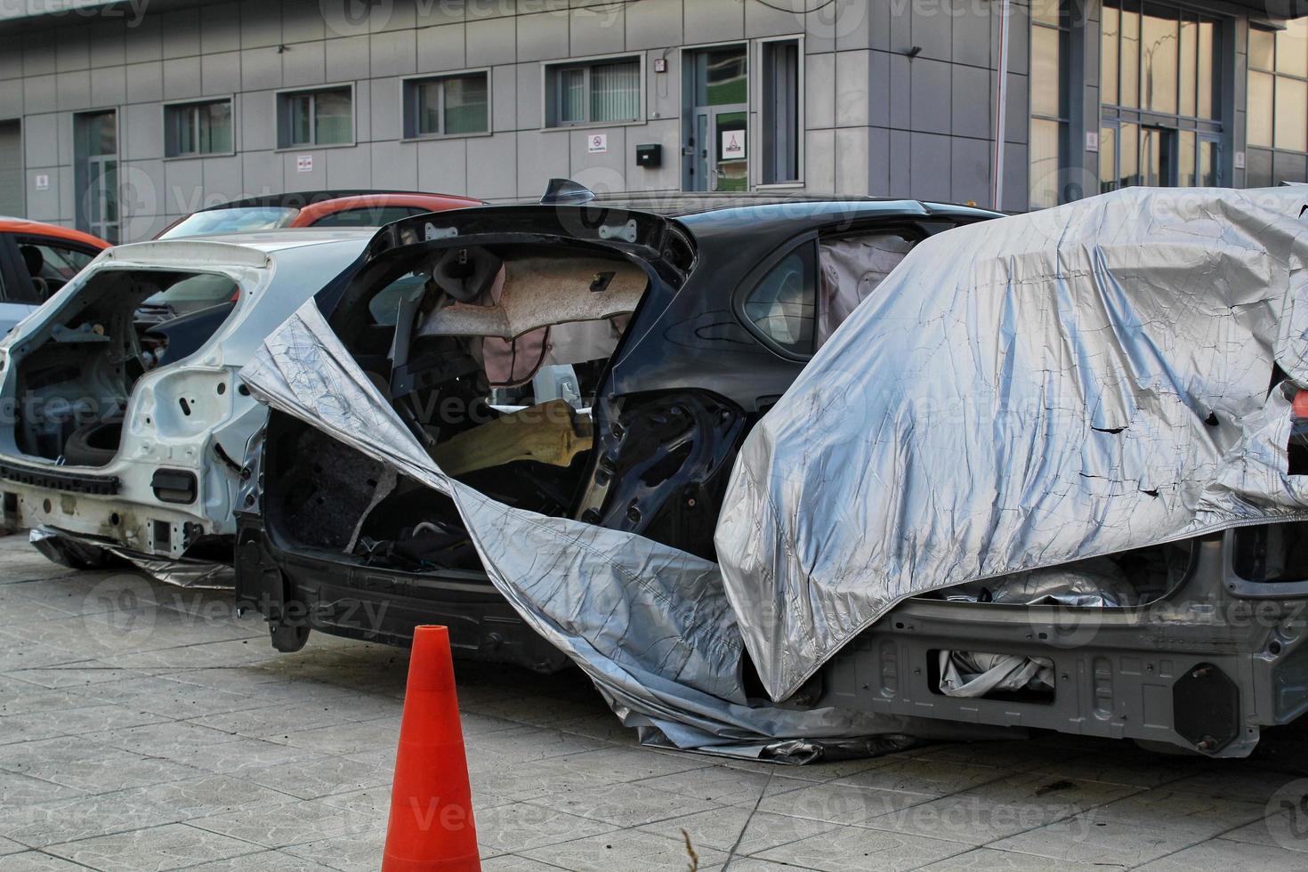 coches viejos dañados aplastados en la demolición del depósito de chatarra de coches. reciclaje de vehículos metálicos en depósito de chatarra. concepto ecológico por volcado de automóviles destrozados. esperando triturar. chatarra industrial. desmontaje de piezas foto