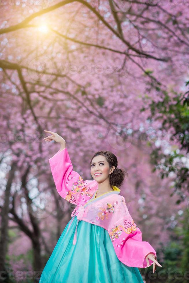 Hanbok, the traditional Korean dress and beautiful Asian girl with sakura photo