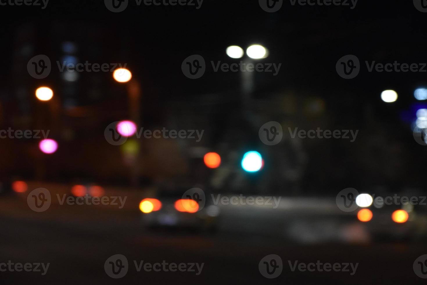 Multicolored lights of the night city. Illuminated night street with car lights. Defocusing the night lights of the city. photo