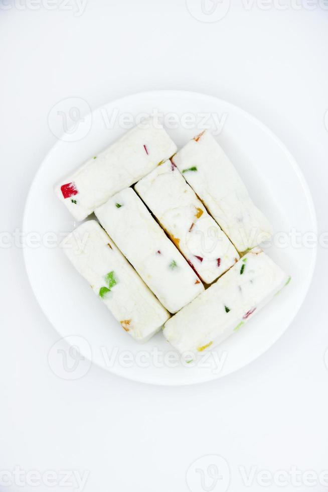 Pieces of juicy marshmallow on a white plate. Sweet oriental snack. Sweets for tea. photo