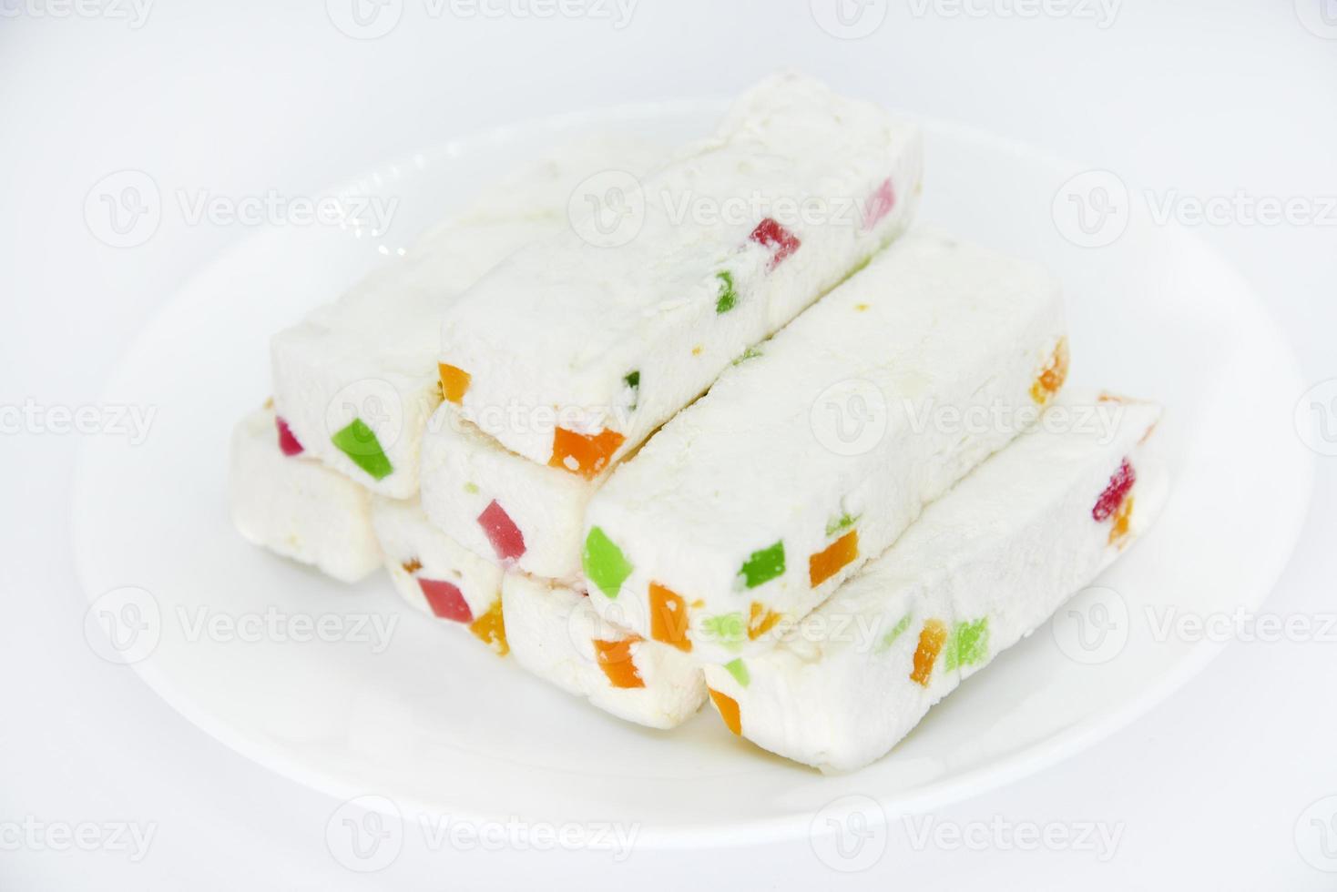 Pieces of juicy marshmallow on a white plate. Sweet oriental snack. Sweets for tea. photo