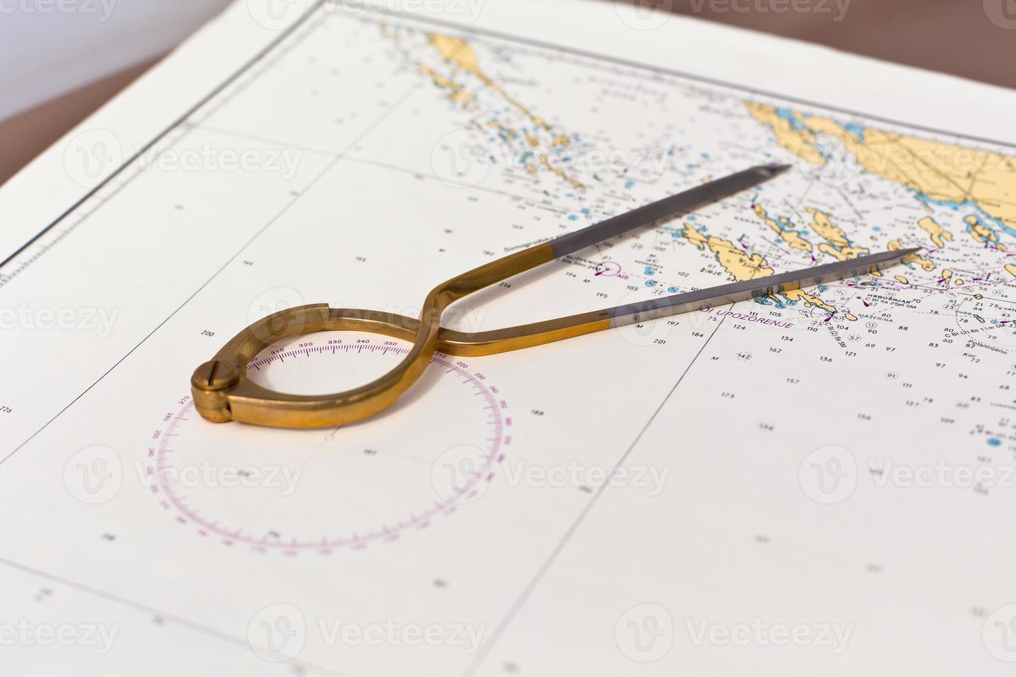 Pair of compasses for navigation on a sea map photo