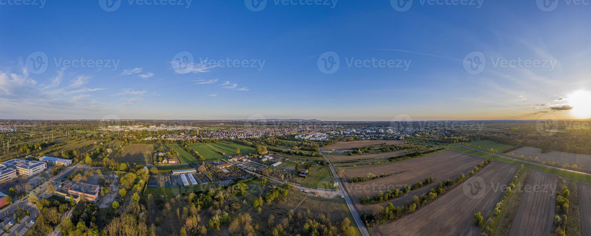 imagen panorámica de drones de la ciudad de moerfelden-walldorf con el horizonte de frankfurt al fondo por la noche foto